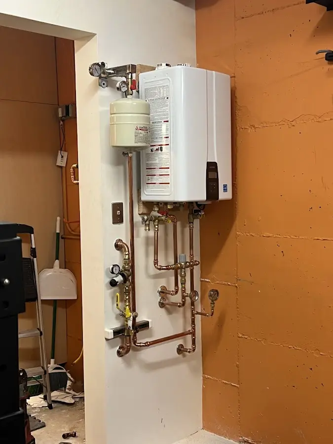 Plumbing technician inspecting water heater connections in Oildale